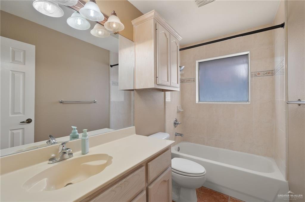 2111 East 25th Street Mission, TX 78574 - Photo 14 of 19 a bathroom with a sink a toilet and a mirror