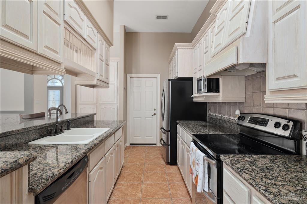 2111 East 25th Street Mission, TX 78574 - Photo 8 of 19 a kitchen with stainless steel appliances granite countertop a sink stove and refrigerator