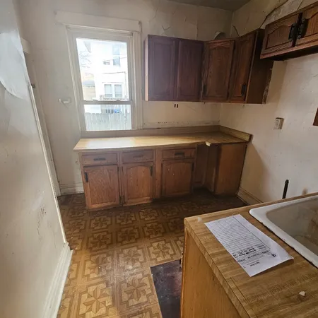 a kitchen with a sink a stove and cabinets