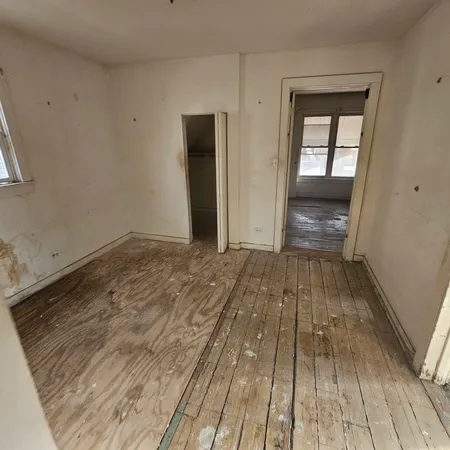 a view of a room with wooden floor and bench