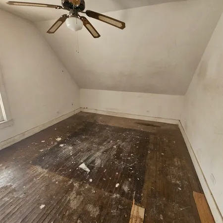 an empty room with a ceiling fan and carpet