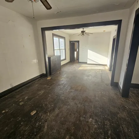 en empty room with an entryway and wooden floor