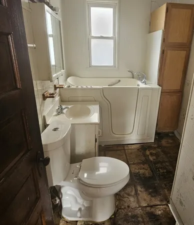 a white toilet sitting next to a bathroom sink and a mirror