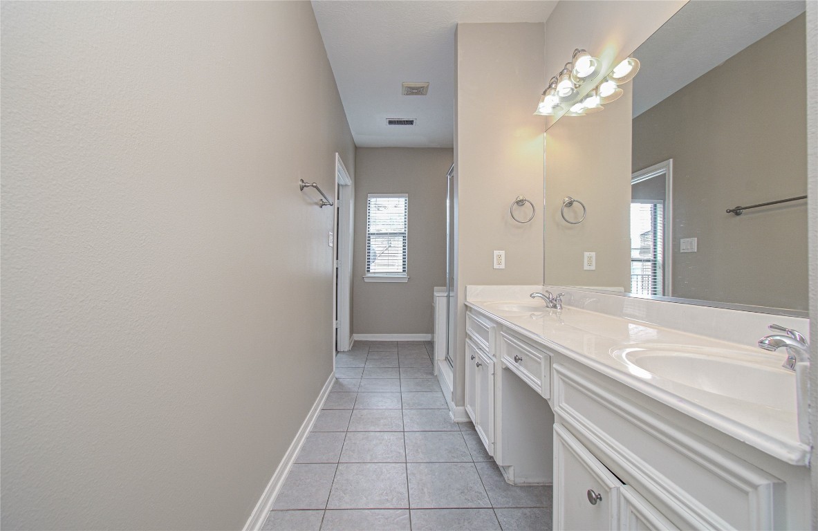 2304 Jackson Street Houston, TX 77004 - Photo 24 of 31 Another view of primary bathroom with double sink vanity, ample counter space, large mirrors, complemented by a window for natural light.