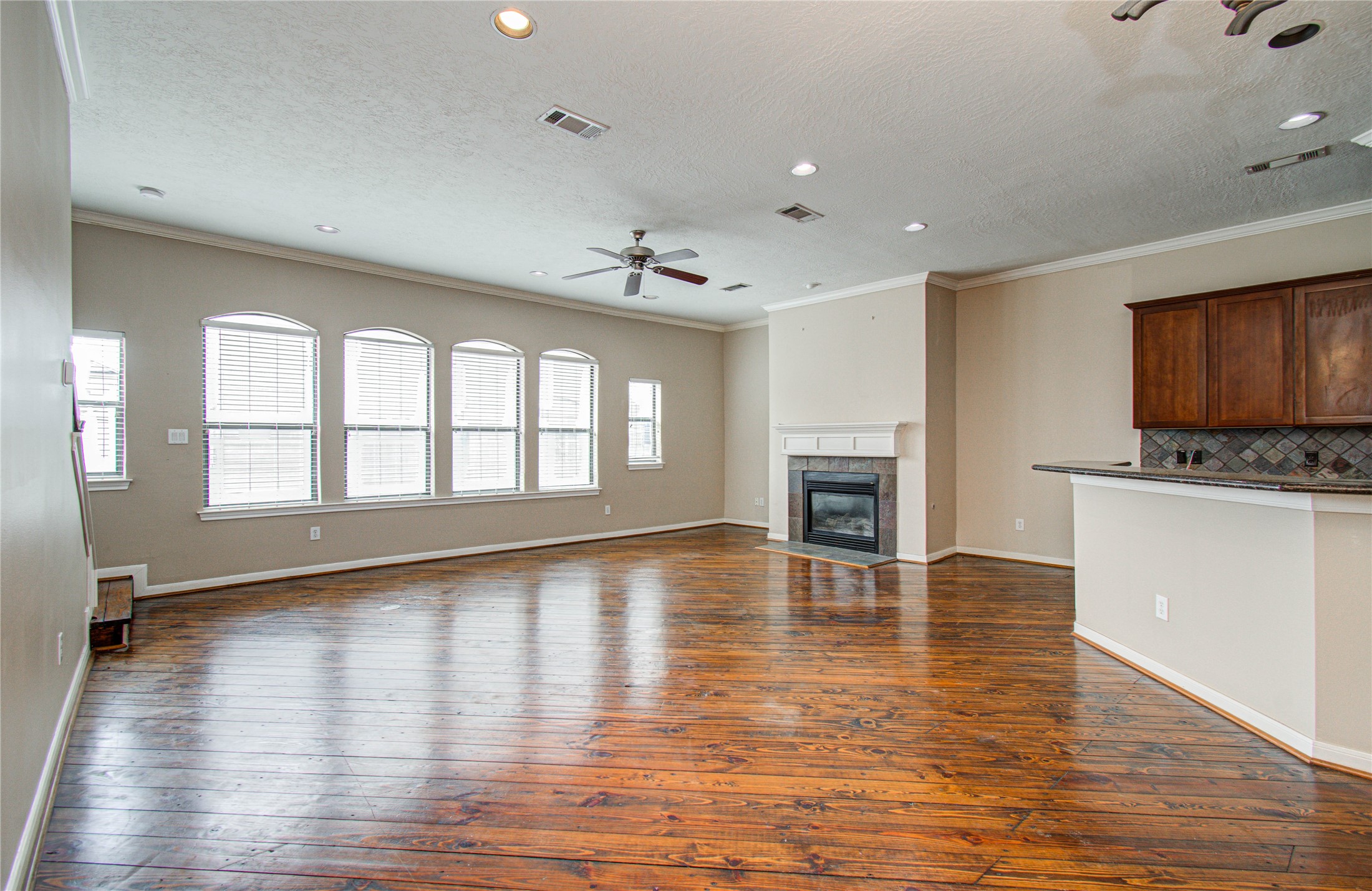 2304 Jackson Street Houston, TX 77004 - Photo 7 of 31 View of the living room from the breakfast area features wood floors, fireplace, and plenty of windows that illuminate the space with natural light. Open layout connects kitchen and breakfast bar to living room great for entertaining guests.