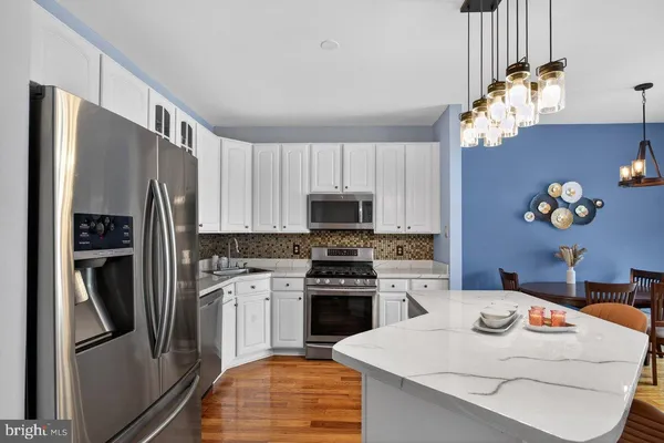 a kitchen with a refrigerator and a stove top oven