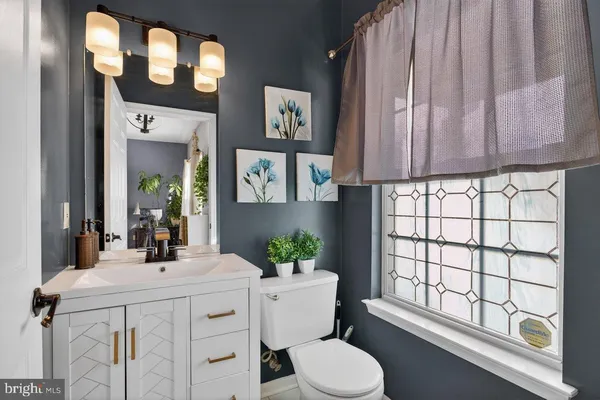 a bathroom with a sink a toilet and a window