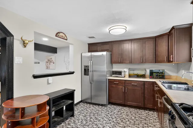 a kitchen with stainless steel appliances a stove refrigerator sink and cabinets
