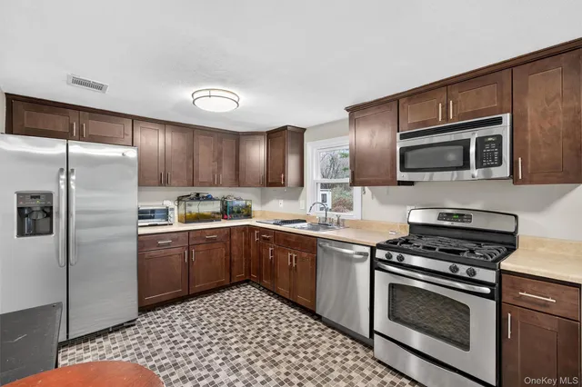 a kitchen with granite countertop a sink stove and refrigerator