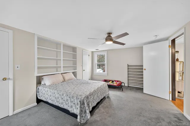 a bedroom with a bed and a ceiling fan