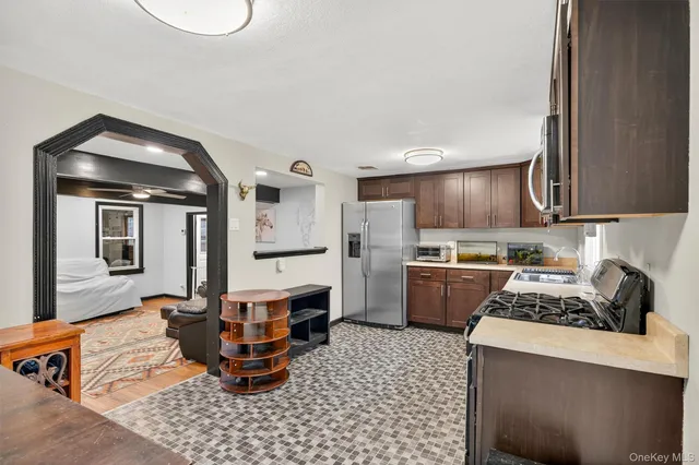 a kitchen with stainless steel appliances granite countertop a stove a sink and a refrigerator