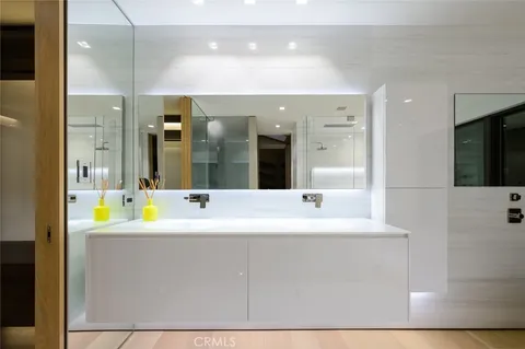 a hallway with white cabinets and black stainless steel appliances