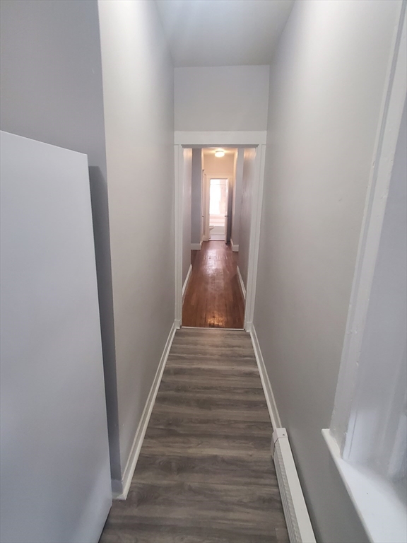 76 Walnut Park, Unit 1 Boston, MA 02119 - Photo 12 of 12 a view of a hallway with wooden floor and staircase