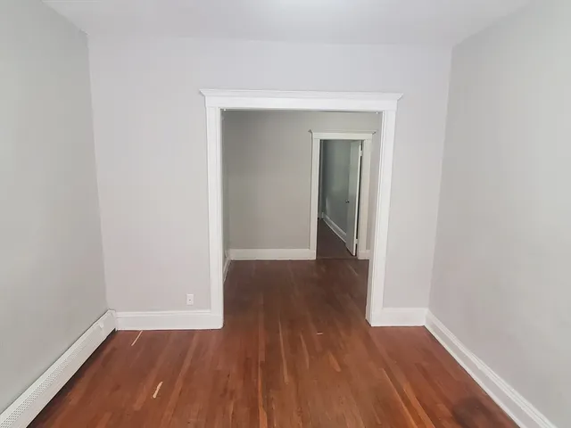a view of a small space with wooden floor and a window