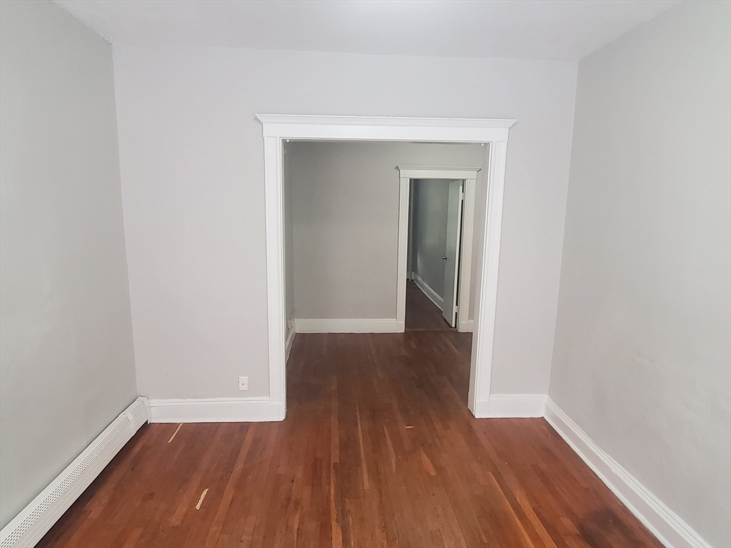 76 Walnut Park, Unit 1 Boston, MA 02119 - Photo 5 of 12 a view of a small space with wooden floor and a window