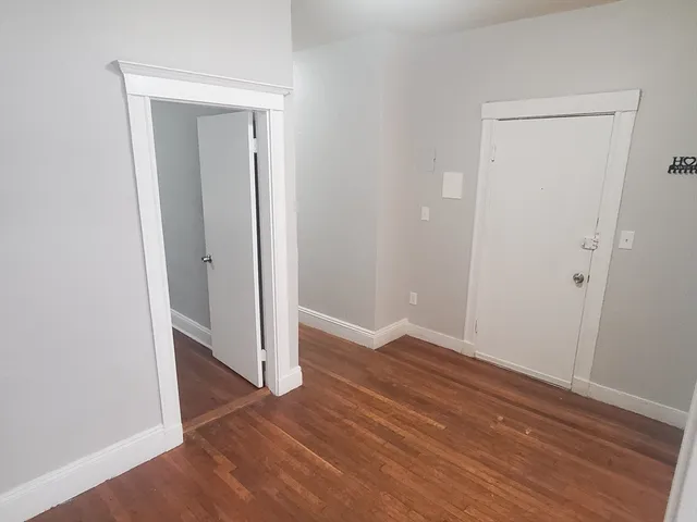 an empty room with wooden floor & closet