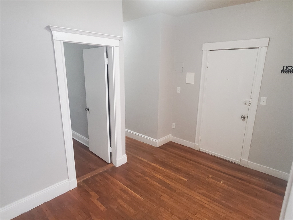 76 Walnut Park, Unit 1 Boston, MA 02119 - Photo 6 of 12 an empty room with wooden floor & closet