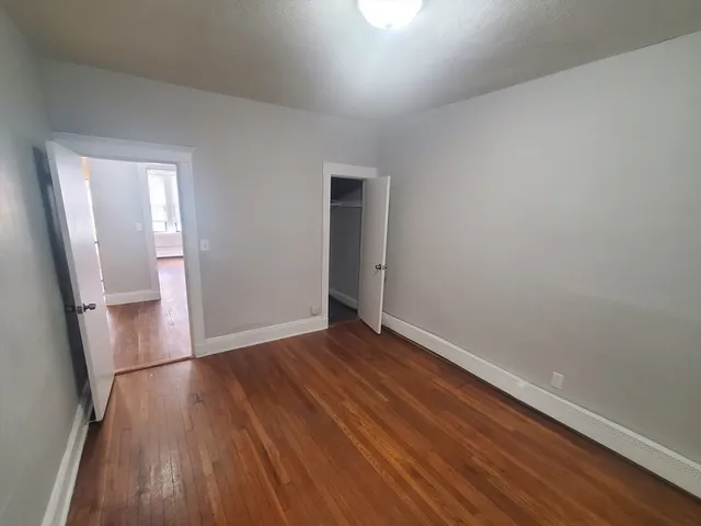 an empty room with wooden floor and wooden door