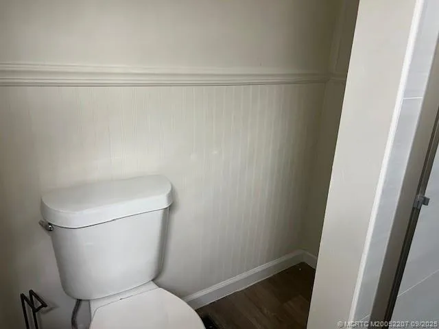a white toilet sitting next to a shower