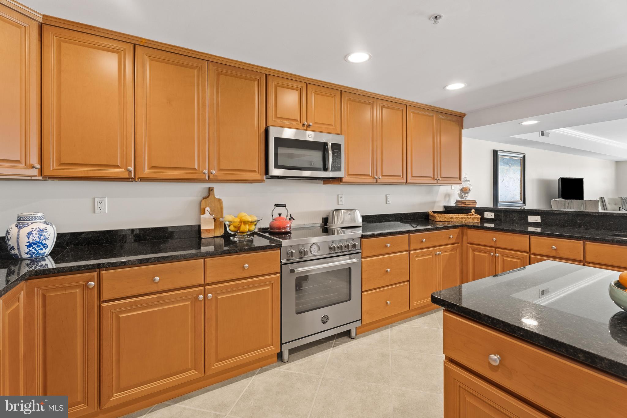 37304 Lighthouse Road, Unit 10 Selbyville, DE 19975 - Photo 25 of 40 a kitchen with granite countertop wooden cabinets stainless steel appliances and a sink