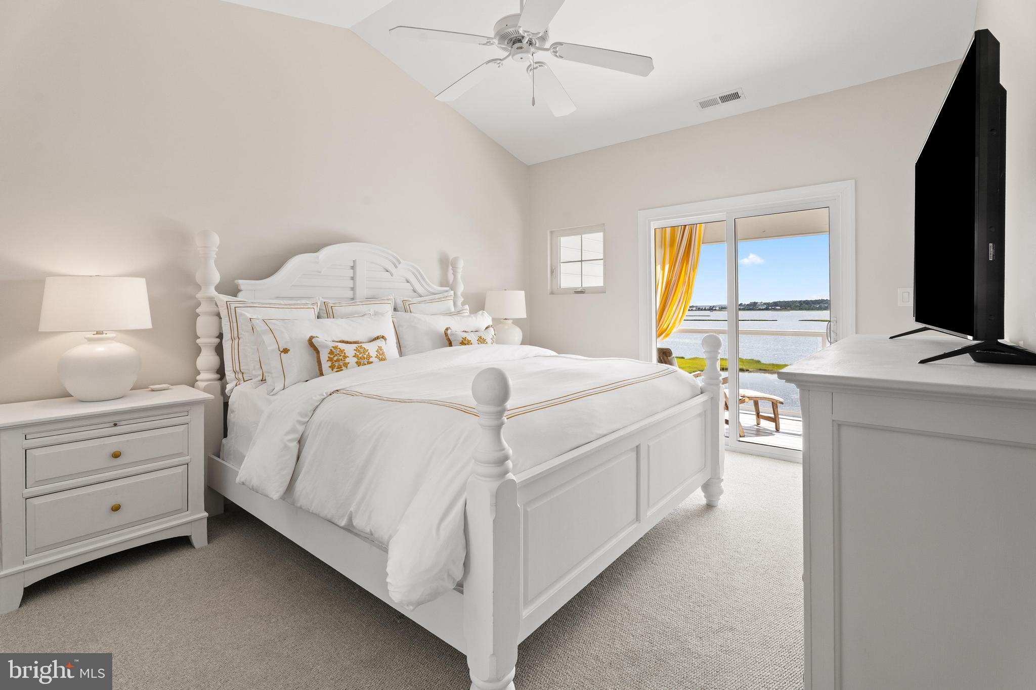 37304 Lighthouse Road, Unit 10 Selbyville, DE 19975 - Photo 32 of 40 a spacious bedroom with a bed and a flat screen tv