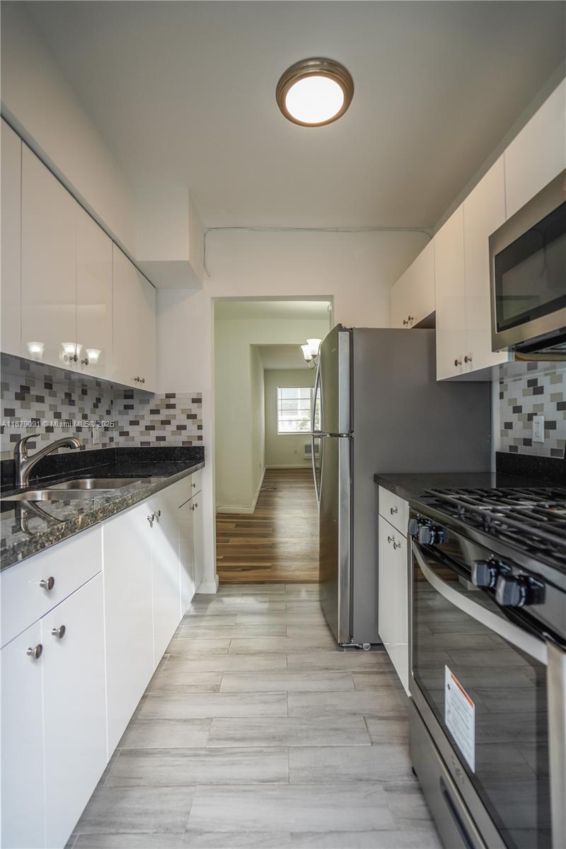 1120 Euclid Avenue, Unit 14 Miami Beach, FL 33139 - Photo 5 of 9 a kitchen with stainless steel appliances a refrigerator stove and sink