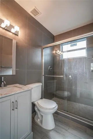 a bathroom with a shower a toilet and a sink