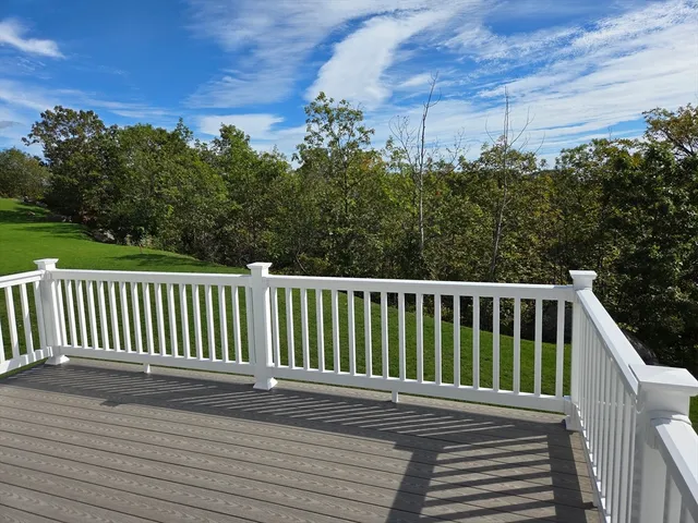 a balcony with wooden floor and yard in back