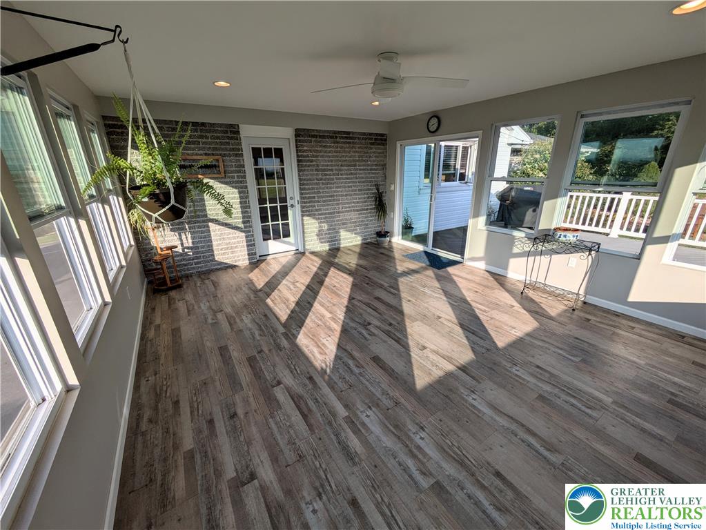 3285 Cherryville Road Northampton, PA 18067 - Photo 43 of 51 Sunlight streams across the LVP wood-patterned flooring of this versatile sunroom space with brick accents.