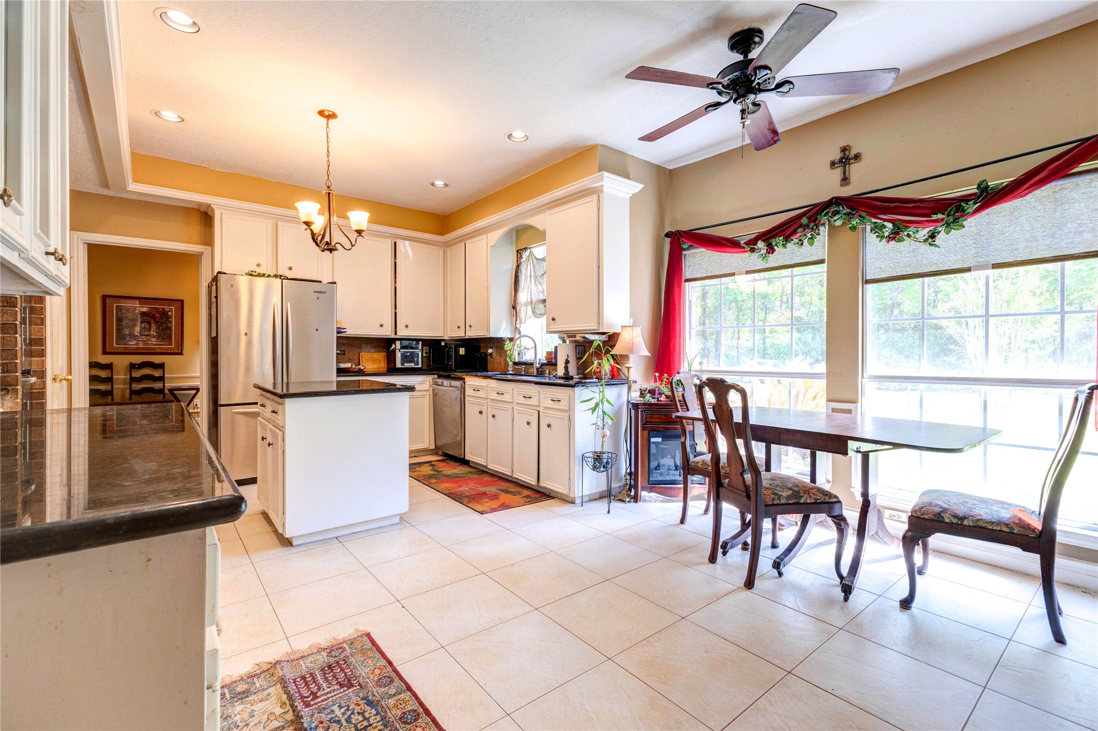 32037 Dobbin-Huffsmith Road Magnolia, TX 77354 - Photo 12 of 49 a kitchen with stainless steel appliances kitchen island granite countertop a table chairs and a refrigerator