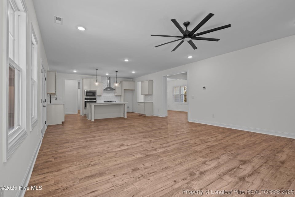 150 Hickory Pointer Way Cameron, NC 28326 - Photo 30 of 50 a view of a livingroom with a ceiling fan & wooden floor