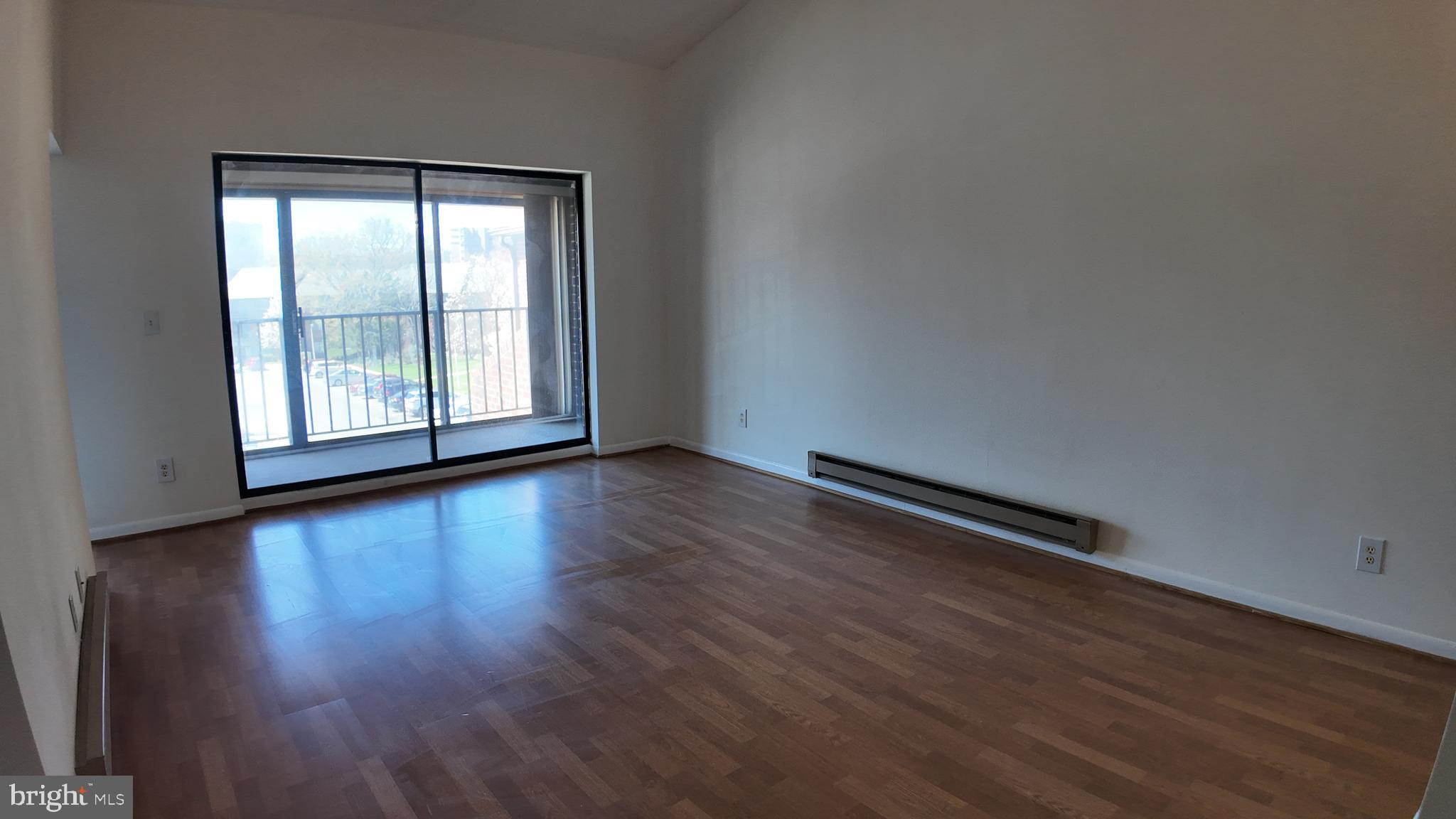 15311 Beaverbrook Court, Unit 903B Silver Spring, MD 20906 - Photo 12 of 36 an empty room with wooden floor and windows