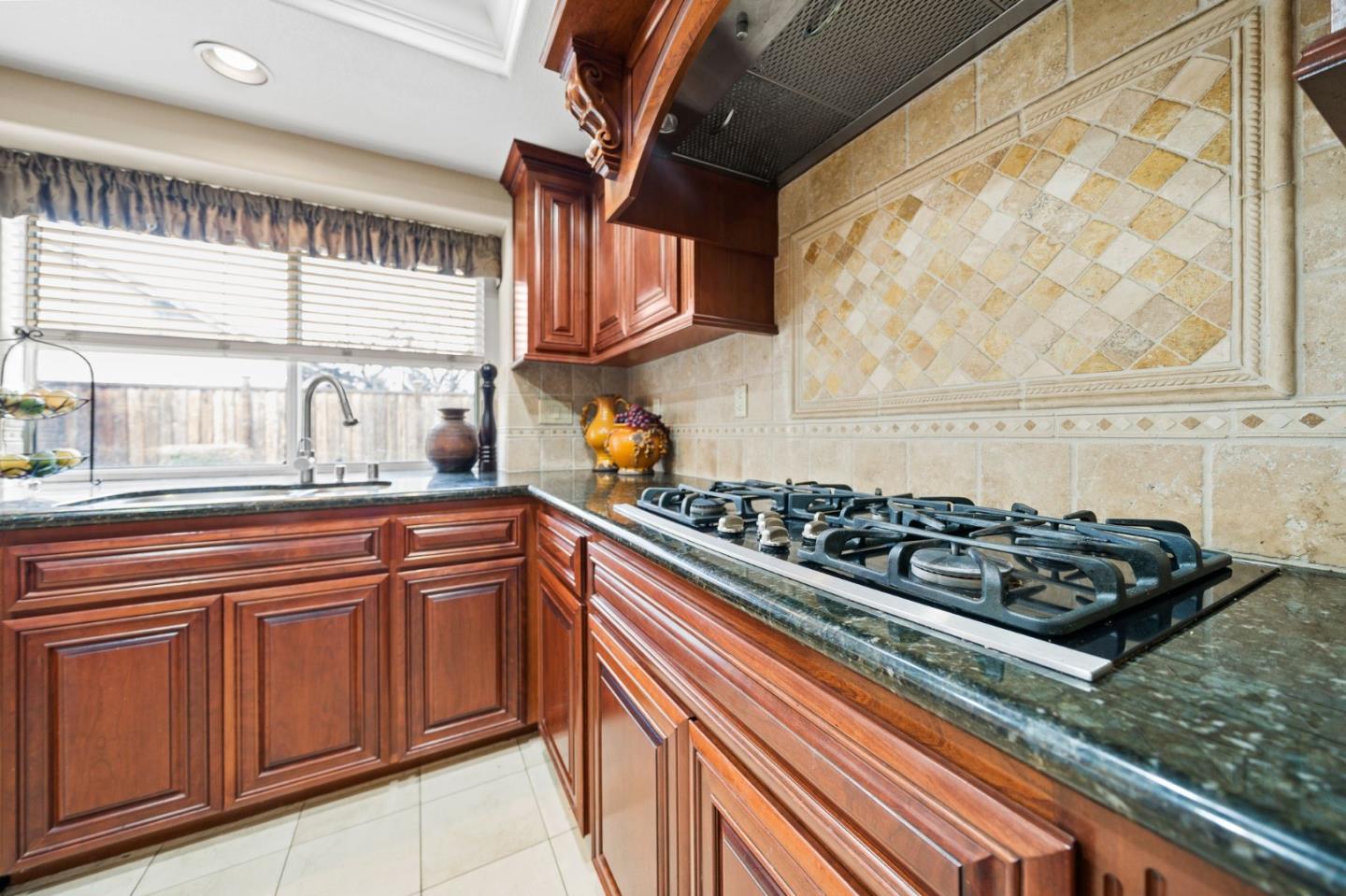 1435 Eagle Street Tracy, CA 95376 - Photo 17 of 24 a kitchen with wooden cabinets and a stove top oven