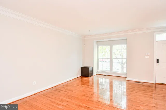 a room with wooden floor and windows