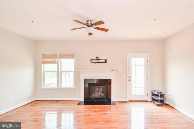 an empty room with windows and fireplace