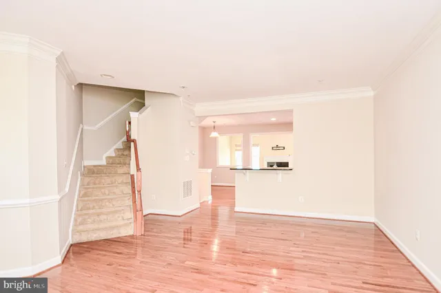 a hallway with wooden floor table and chairs