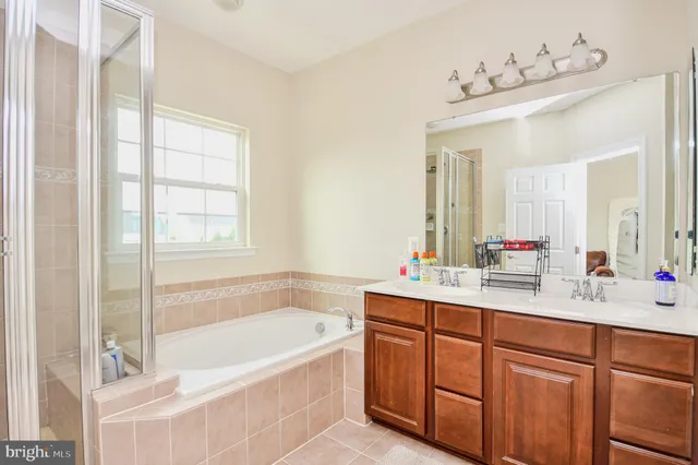 a bathroom with a tub sink and mirror