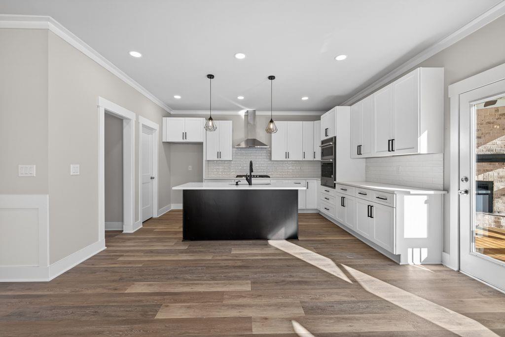 4947 Old Orr Road Flowery Branch, GA 30542 - Photo 14 of 60 a large white kitchen with kitchen island a sink a center island stainless steel appliances and a window