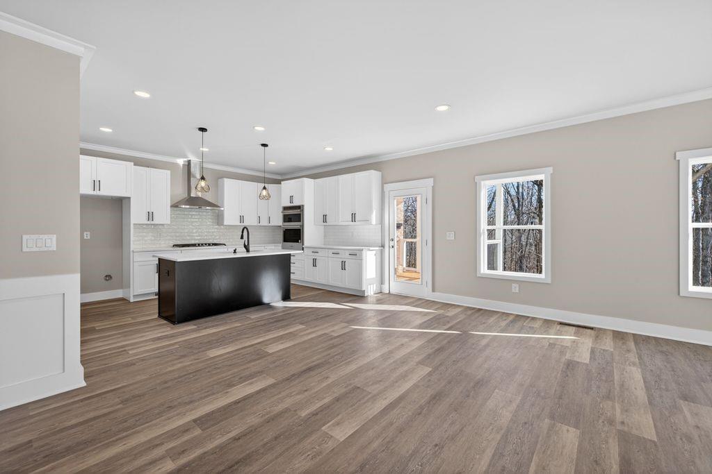 4947 Old Orr Road Flowery Branch, GA 30542 - Photo 23 of 60 a large white kitchen with stainless steel appliances kitchen island a large counter top and a wooden floors
