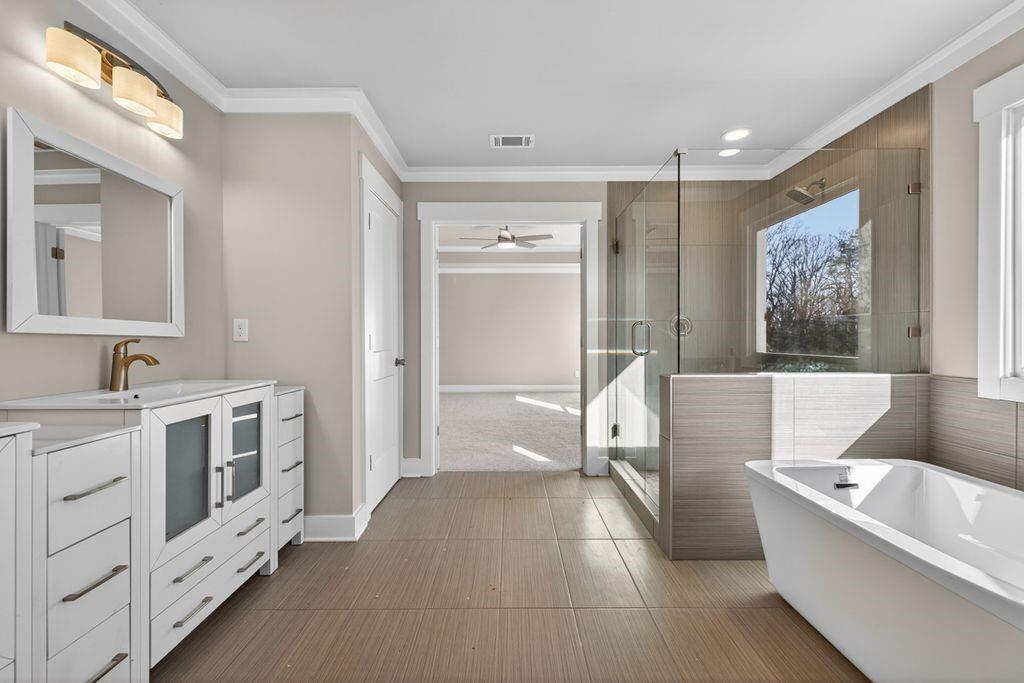 4947 Old Orr Road Flowery Branch, GA 30542 - Photo 44 of 60 a bathroom with a tub a double vanity sink a vanity and a large mirror