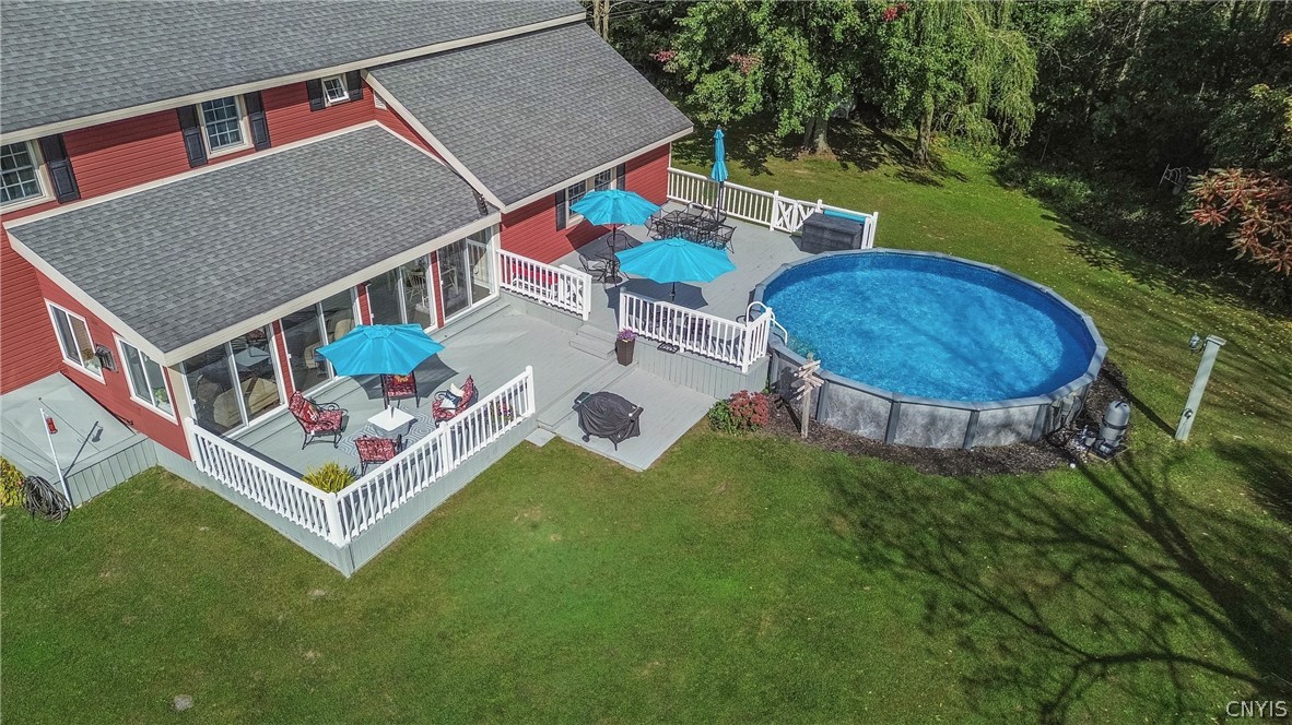 15384 Fuller Road Adams, NY 13606 - Photo 23 of 50 An aerial perspective showcases a multi-level deck overlooking a large circular pool and green lawn.