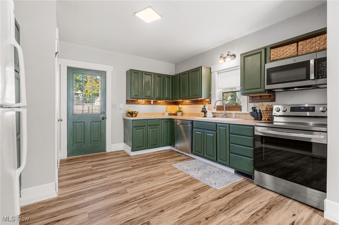 21 South 3rd Street Rittman, OH 44270 - Photo 12 of 39 Kitchen with green cabinetry, appliances with stainless steel finishes, light countertops, and light wood finished floors