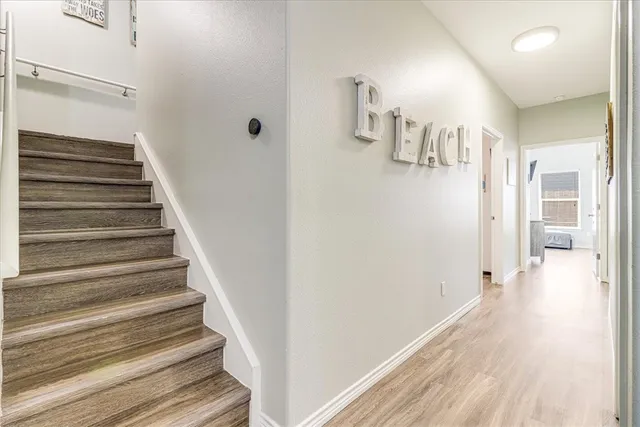 a view of a hallway with wooden floor and entryway