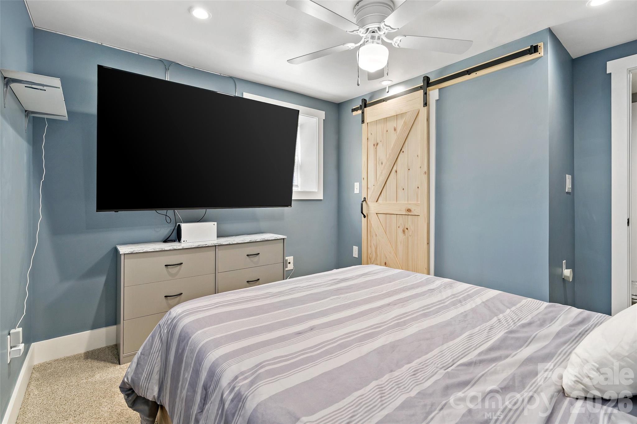 153 Arrowood Corner Road Mars Hill, NC 28754 - Photo 26 of 34 a bedroom with a bed and a flat screen tv