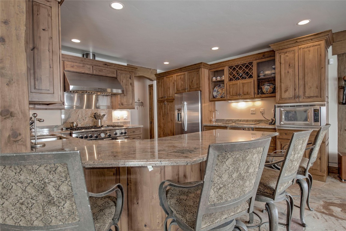 68 Snowy Ridge Road Breckenridge, CO 80424 - Photo 16 of 42 a kitchen with stainless steel appliances granite countertop a stove top oven a sink and chairs