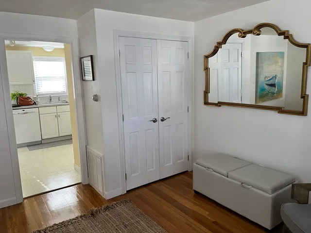 a view of a hallway with wooden floor and cabinet