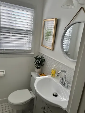 a bathroom with a sink a toilet and a mirror