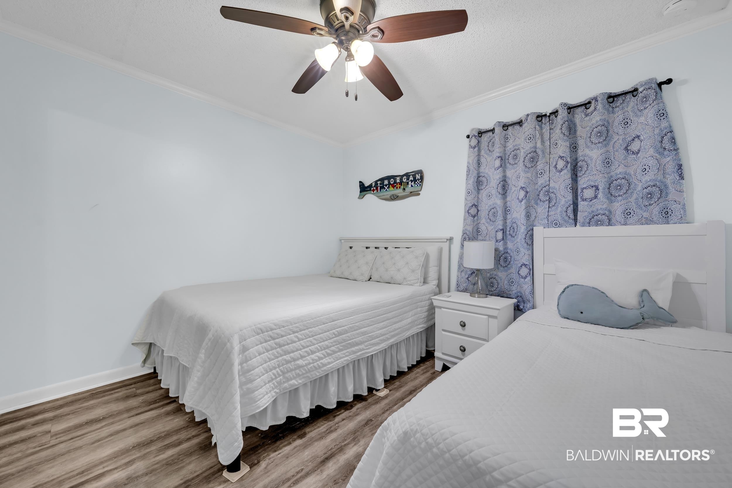 400 Plantation Road, Unit 2118 Gulf Shores, AL 36542 - Photo 19 of 59 Light-filled room featuring wood-finish flooring, white baseboards, and a contemporary ceiling fan with integrated lighting