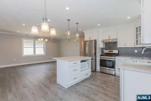 a kitchen with a refrigerator and a stove top oven