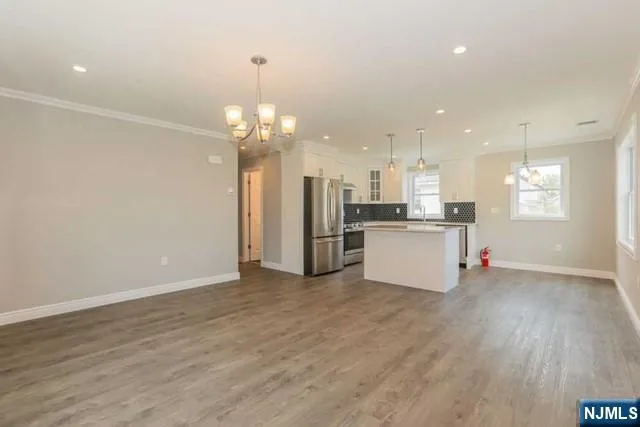 a view of a kitchen with a sink wooden cabinets and stainless steel appliances
